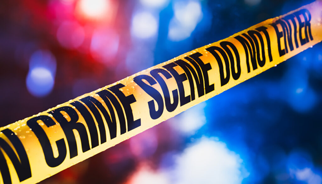 Crime Scene tape, selective focus showing crime scene against red and blue police lights