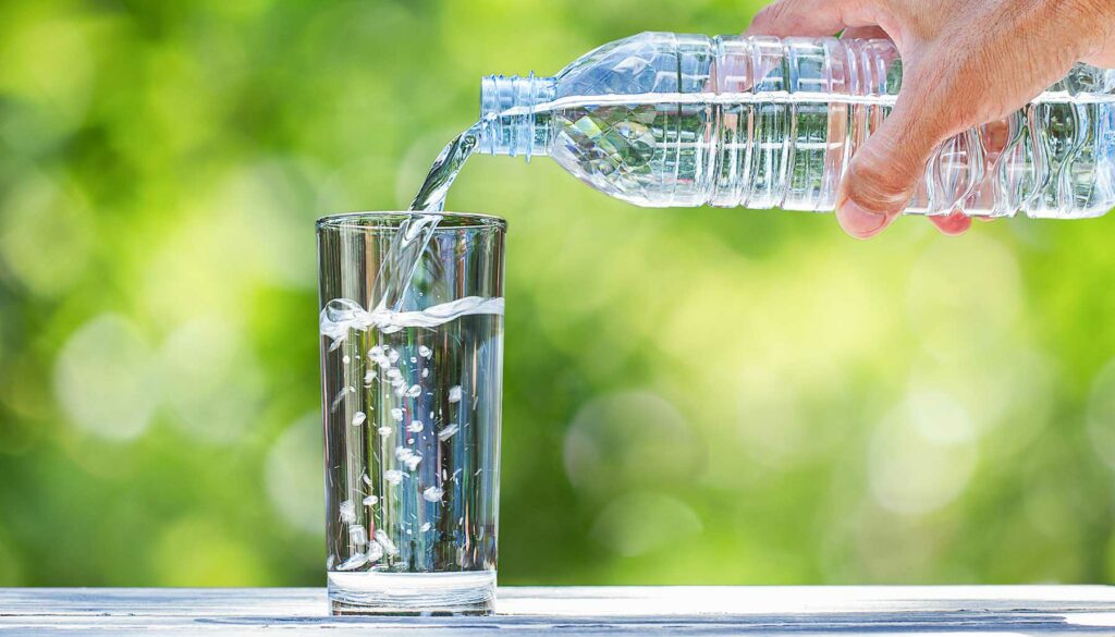 pouring bottled water into a glass