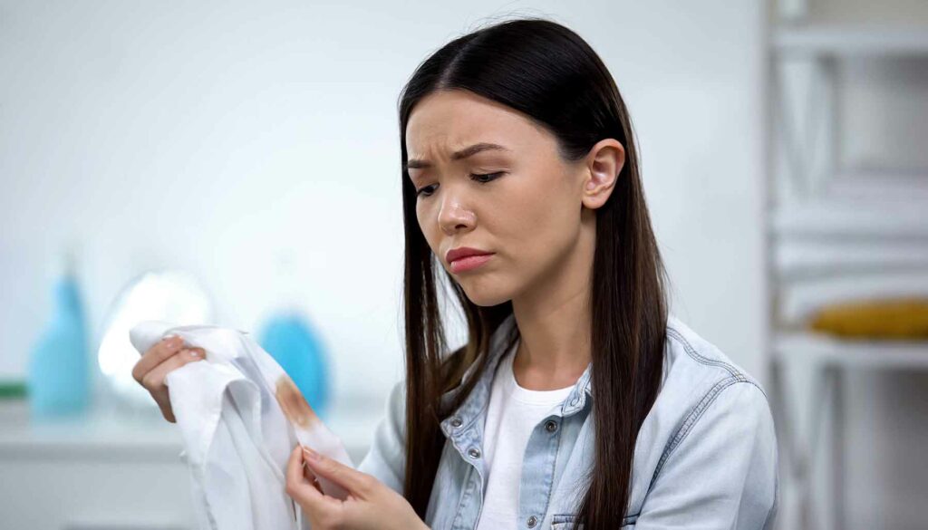 woman holding a shirt with a stain on it