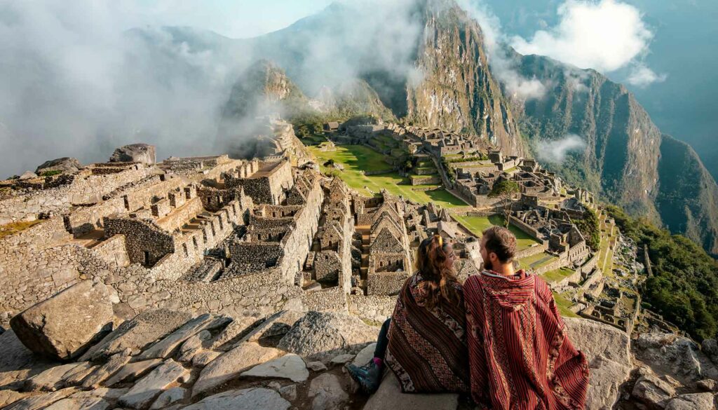 a couple sitting and looking at Machu Picchu