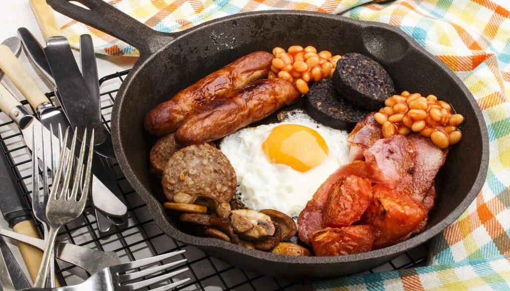 full irish breakfast with sausages, back bacon, egg, tomatoes, baked beans, black pudding