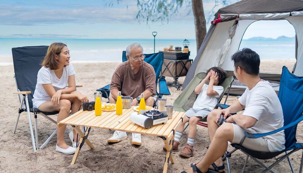 family with senior and kids relaxing and camping on tropical beach during summer holiday. 