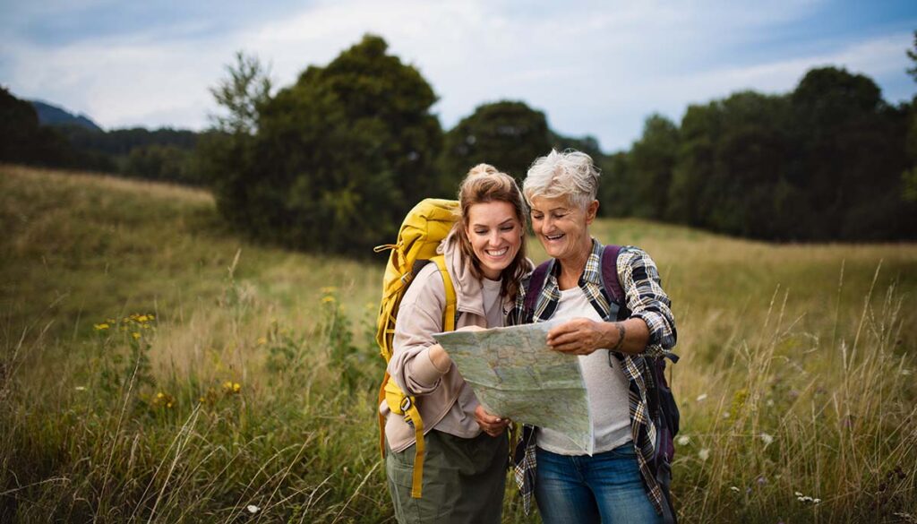 woman and her mother with a map on a scenic hike 