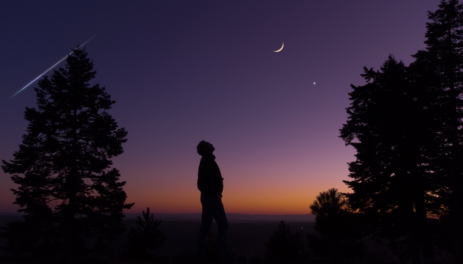 a silhouette figure looking up at a new moon