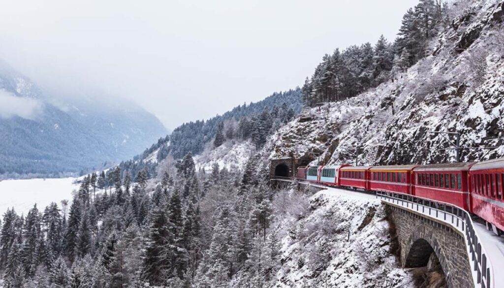 Glacier Express coming around the mountain in Switzerland during snowy winter