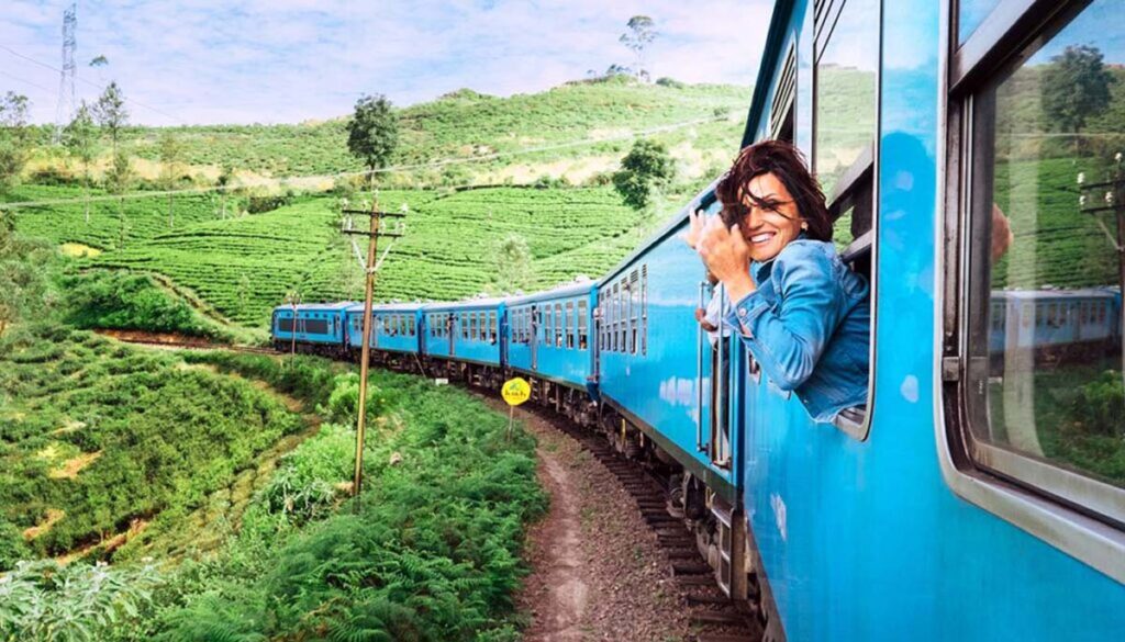 blue train in Sri Lanka with woman smiling out the window
